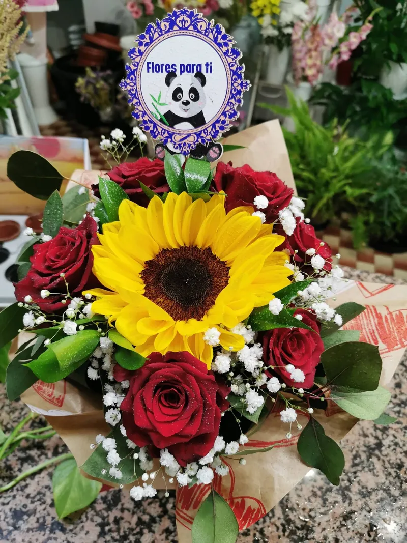 Ramo de girassol com rosas vermelhas e gipsófila embrulhado em papel kraft